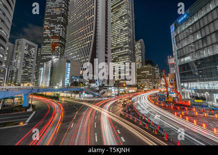 Stadtbild Szene in der Nacht. Auto Licht Wanderwege durch Construction Yard und Wolkenkratzer. Heavy traffic night in Shinjuku, dem Geschäftsviertel in Tokio Stockfoto