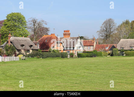 Eine Reihe von traditionellen englischen Dorf Häuser in Oxfordshire mit Village Green im Vordergrund. Stockfoto