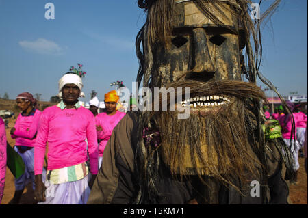 Tribal Mann mit einem Holz- Maske. + tribal Tänzerinnen. Sie alle gehören zu einer Stammes- kulturelle Gruppe, die Tänze ist eine lokale Messe durchführen (Indien) Stockfoto