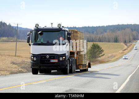 Salo, Finnland - 19 April, 2019: Weiß Renault Trucks semi schleppt eine große Last von Schnittholz auf Schwanenhals Anhänger auf der Autobahn an einem Tag des Frühlings. Stockfoto