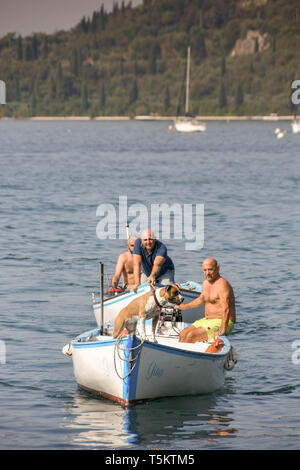 GARDA, Gardasee, Italien - September 2018: Kleine Fischerboote der Rückkehr in den Hafen von Garda. Ein Hund ist in der vorderen Boot. Stockfoto