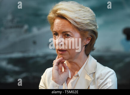 Wolgast, Deutschland. 25 Apr, 2019. Verteidigungsminister Ursula von der Leyen (CDU) steht für eine Korvette K130 auf der Werft Gelände der Peene Werft, die zu der Lürssen Werft in Kiel legen. Während der feierlichen Zeremonie eine Gedenkmünze und einer Euro-münze sind unter dem Kiel gelegt, eine Tradition. Der Auftrag hat ein Gesamtvolumen von rund zwei Milliarden Euro. Die ersten Schiffe werden sukzessive ab 2022 von der "Arbeitsgemeinschaft K130" geliefert werden. Home port Rostock-Warnemünde. Quelle: Stefan Sauer/dpa/Alamy leben Nachrichten Stockfoto