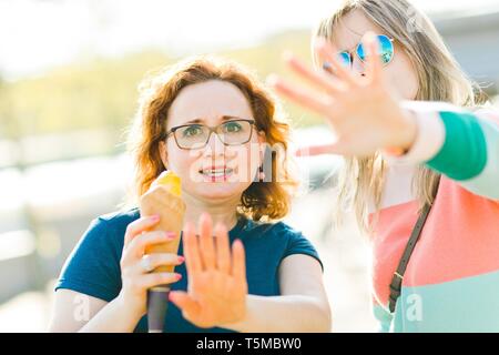 Zwei verärgerte Frauen zeigen Gesten kein Foto bitte. Abdeckung mit Händen Stockfoto