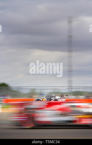 Aktion geschossen von Porsche 911 Rennwagen hinter einer Unschärfe der anderen Rennen auto im Vordergrund, WEC 6 Stunden Silverstone 2018 gesehen Stockfoto