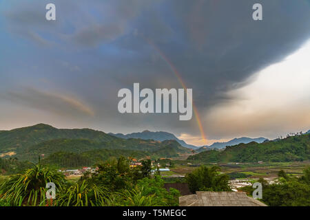 Bunte Regenbogen über einem kleinen Tal Dorf in SaPa, Vietnam, Asien Stockfoto