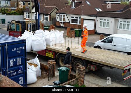 Ein Tieflader Lkw entladen große Säcke mit Sand mit Hilfe einer Hebevorrichtung und Auslieferung an ein privates Haus, für das derzeit Bauarbeiten, Surrey, Großbritannien Stockfoto