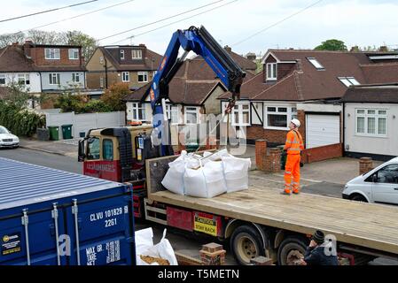 Ein Tieflader Lkw entladen große Säcke mit Sand mit Hilfe einer Hebevorrichtung und Auslieferung an ein privates Haus, für das derzeit Bauarbeiten, Surrey, Großbritannien Stockfoto