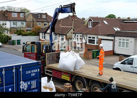 Ein Tieflader Lkw entladen große Säcke mit Sand mit Hilfe einer Hebevorrichtung und Auslieferung an ein privates Haus, für das derzeit Bauarbeiten, Surrey, Großbritannien Stockfoto