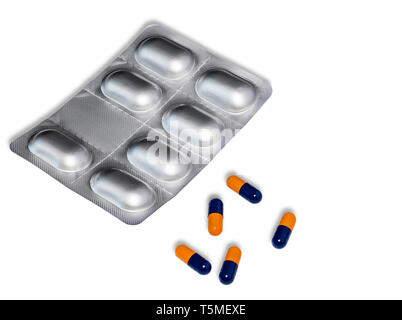 Eine Blisterpackung von Pillen mit fünf orangen und blauen Pillen auf den Tisch. Auf einem weißen Hintergrund. Stockfoto