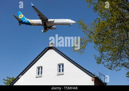 Flugzeuge landen auf DŸsseldorf International Airport, DUS, Deutschland, Häuser im Stadtteil Lohausen, direkt an der Start- und Landebahn Stockfoto