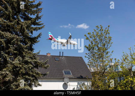 Flugzeuge landen auf DŸsseldorf International Airport, DUS, Deutschland, Häuser im Stadtteil Lohausen, direkt an der Start- und Landebahn Stockfoto