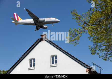 Flugzeuge landen auf DŸsseldorf International Airport, DUS, Deutschland, Häuser im Stadtteil Lohausen, direkt an der Start- und Landebahn Stockfoto