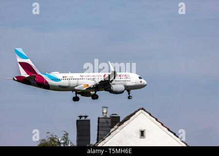 Flugzeuge landen auf DŸsseldorf International Airport, DUS, Deutschland, Häuser im Stadtteil Lohausen, direkt an der Start- und Landebahn Stockfoto