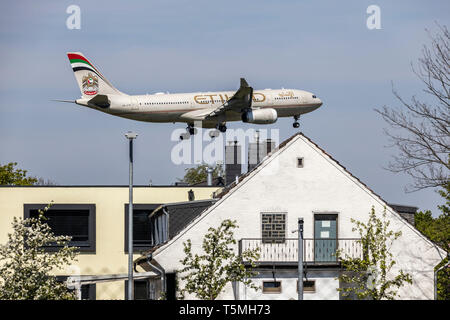 Flugzeuge landen auf DŸsseldorf International Airport, DUS, Deutschland, Häuser im Stadtteil Lohausen, direkt an der Start- und Landebahn Stockfoto