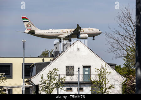 Flugzeuge landen auf DŸsseldorf International Airport, DUS, Deutschland, Häuser im Stadtteil Lohausen, direkt an der Start- und Landebahn Stockfoto