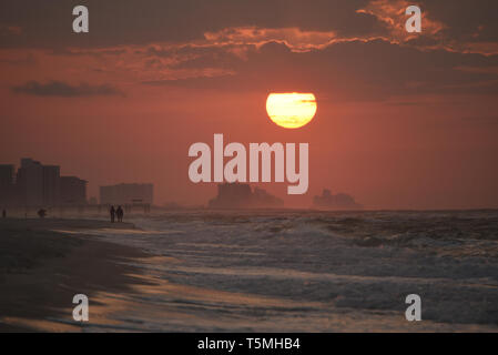 Helle Sonnenaufgang, mit Wolken, Strand entlang über den Atlantik mit Wellen entlang der Küste brechen, in Gulf Shores, Orange Beach, Alabama, USA Stockfoto