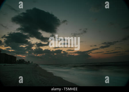 Helle Sonnenaufgang, mit Wolken, Strand entlang über den Atlantik mit Wellen entlang der Küste brechen, in Gulf Shores, Orange Beach, Alabama, USA Stockfoto