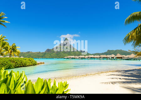 Blick auf den Mount Otemanu durch türkisfarbene Lagune und Überwasser Bungalows auf der tropischen Insel Bora Bora, Tahiti, Französisch Polynesien, Pazifik. Stockfoto