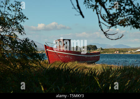 Eine alte rote stillgelegten Fischerboot in Connemara, Irland, baufällig ist. Entlang der wilden Atlantikküste in Connemara an Irlands Westen coas Stockfoto