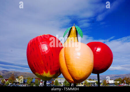 Apfel Birne Kirsche Aprikose Stein Obst Symbol in der Mitte des Cromwell Cherry Capital bekannte touristische Destination blue sky Green gras wiese an einem sonnigen Tag Stockfoto