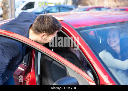 Lächelnden jungen Mann mit einer Dame im Auto Stockfoto