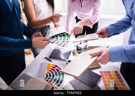 Geschäftsleute aus der Hand wählen Sie Farbe aus verschiedenen Farbmustern im Büro Stockfoto