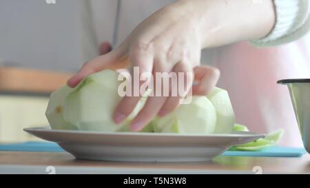 Eine Frau, die eine Apple auf einer Platte geschält. Teil 3. Frau löscht die Tabelle. Stockfoto