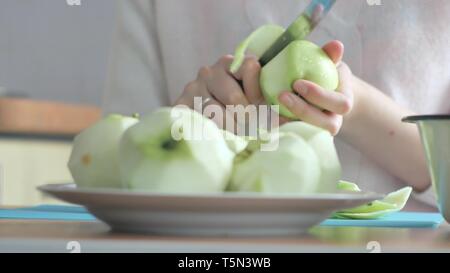 Eine Frau, die eine Apple auf einer Platte geschält. Teil 3. Frau löscht die Tabelle. Stockfoto