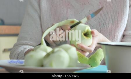 Eine Frau, die eine Apple auf einer Platte geschält. Teil 2. Frau löscht die Tabelle. Stockfoto