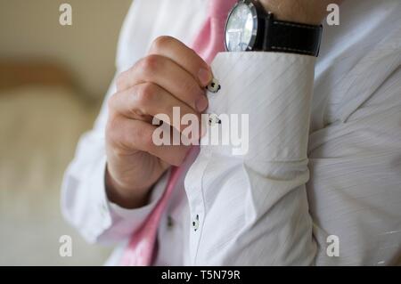 Mann Manschettenknöpfe auf weißem Shirt Stockfoto