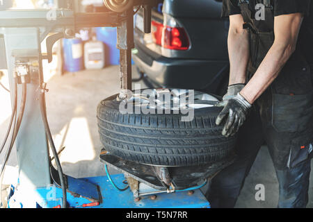 Automechaniker ändern Reifen auf die Felge im Service garage Stockfoto