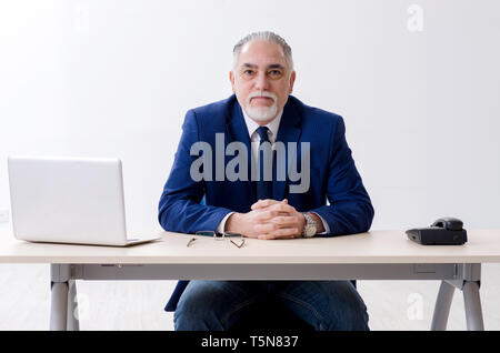 Alter Geschäftsmann Yoga Übungen im Büro Stockfoto
