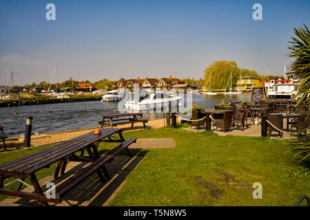 Das Riverside Biergarten der Swan Inn, Horning, Norfolk. Der Biergarten hat unverdorbene Ausblicke auf den Fluss Bure und die Motorboote navigieren im Stockfoto