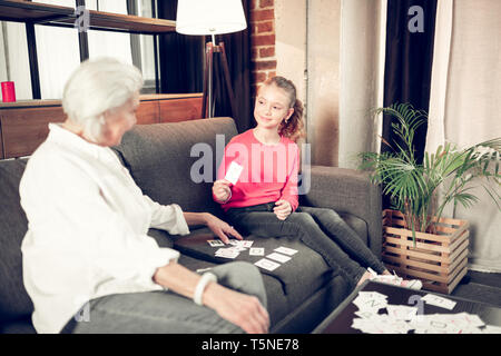 Dark-eyed girl Jeans und Rosa shirt Studieren mit Oma Stockfoto