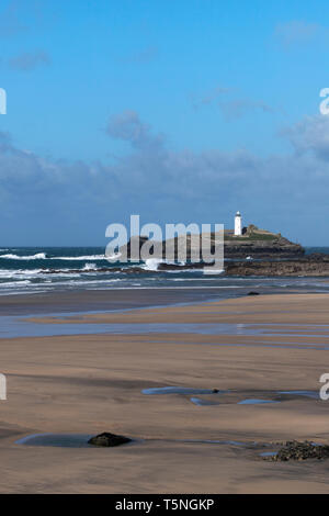 Der Sturm ist vorüber. Eine sonnige Aussicht an einem windigen Tag der Godrevy Leuchtturm über leere Strand. Gwithian, Cornwall. März 2019 Stockfoto