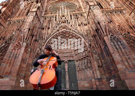 Cellist Brice Bauer vor der Kathedrale Notre Dame de Strasbourg, Grande-Île de Strasbourg, Frankreich. Stockfoto