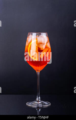 Aperol Spritz Cocktail in Glas auf schwarz Reflexion Hintergrund. Stockfoto