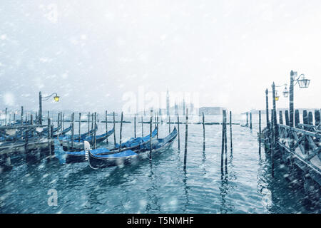 Traditionelle italienische Gondeln zu den Polen in Europa Venedig, in der Nähe der Innenstadt und Saint Mark Square mit einem Hintergrund Blick auf die Kirche von Sa günstig Stockfoto