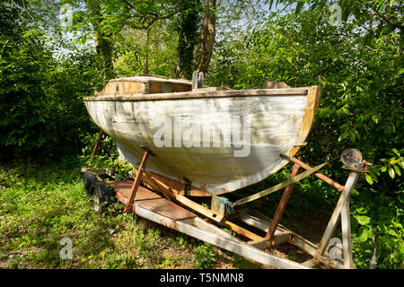 Alte verwitterte bewachsenen Boot in einem Garten, Cornwall, England Stockfoto