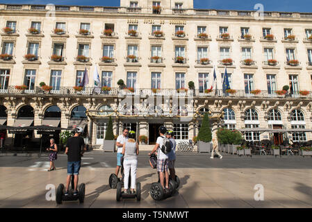 Touristen auf Sedgways vor dem Grand Hotel de Bordeaux, Gironde, Frankreich. Stockfoto