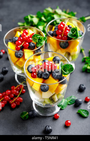 Frischer Salat mit Früchten und Beeren in Glas Stockfoto