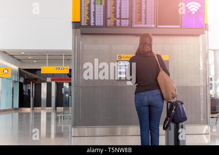 Frau mit Handgepäck auf dem Flug in den Flughafen. Stockfoto