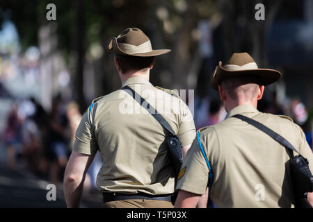 Zwei junge Soldaten gerne zu Fuß zu Ihrem Treffpunkt für die Veranstaltung in voller Uniform mit ihren Hüten und Gewehren gekleidet Stockfoto