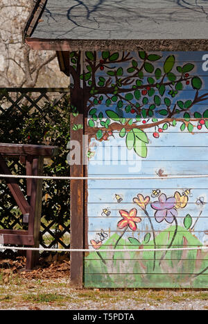 Blumen und Zweige auf der Außenwand eines Holzhütte lackiert Stockfoto