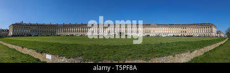 BATH, England - 19. APRIL 2019: Royal Crescent, georgianische Häuser Architektur mit Windows Säulen, Lamp Post an einem sonnigen Tag mit klaren Himmel. Stockfoto