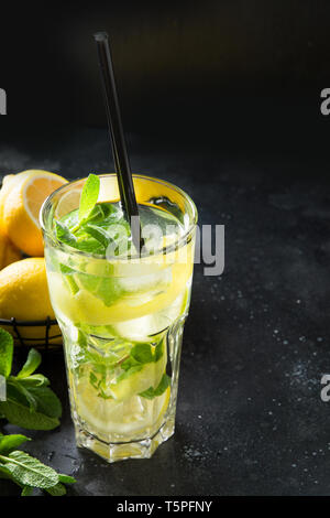 Mojito Cocktail oder Limonade mit Limette und Minze in highball Glas auf Schwarz. Close Up. Sommer erfrischendes Getränk. Stockfoto