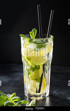 Mojito Cocktail oder Limonade mit Limette und Minze in highball Glas auf Schwarz. Close Up. Sommer erfrischendes Getränk. Stockfoto