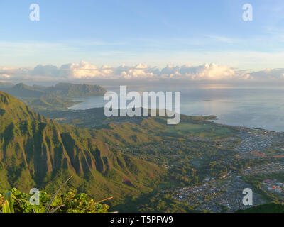Hohe Aussicht auf Kaneohe und die Berge von Oahu mit einer aufgehenden Sonne von hinten Stockfoto