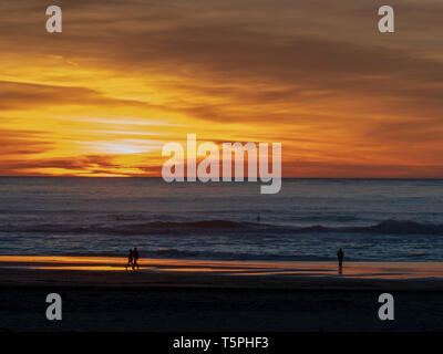 Während der Dämmerung Sonnenuntergang über dem Pazifischen Ozean mit Paaren, Surfer und Wanderer Stockfoto
