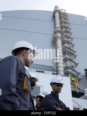 Kiew, Kiew, Ukraine. 26 Apr, 2019. Arbeitnehmer sind zu Fuß vor der neuen Schutzkonstruktion in der 4. Block des Kernkraftwerks Tschernobyl während des Jubiläums. Ukrainer markiert der 33. Jahrestag der Katastrophe von Tschernobyl. Die Explosion der vierte Block des Kernkraftwerks Tschernobyl am 26. April 1986 immer noch als der größte Unfall in der Geschichte der Atomenergie. Credit: Pavlo Gontschar/SOPA Images/ZUMA Draht/Alamy leben Nachrichten Stockfoto